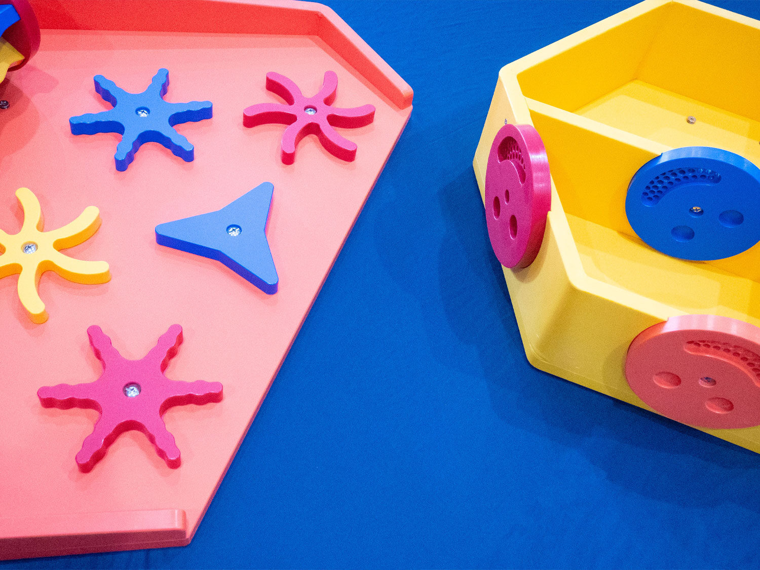 a spinner water play table and smiley face water play table on a blue background